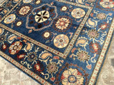 Vintage Oushak Hand Knotted Wool Rug featuring a deep blue field with large floral medallions and an intricate ornate border in cream and terracotta hues