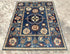 Vintage Oushak Hand Knotted Wool Rug with deep navy blue background, large floral medallions, and intricate cream and red botanical patterns
